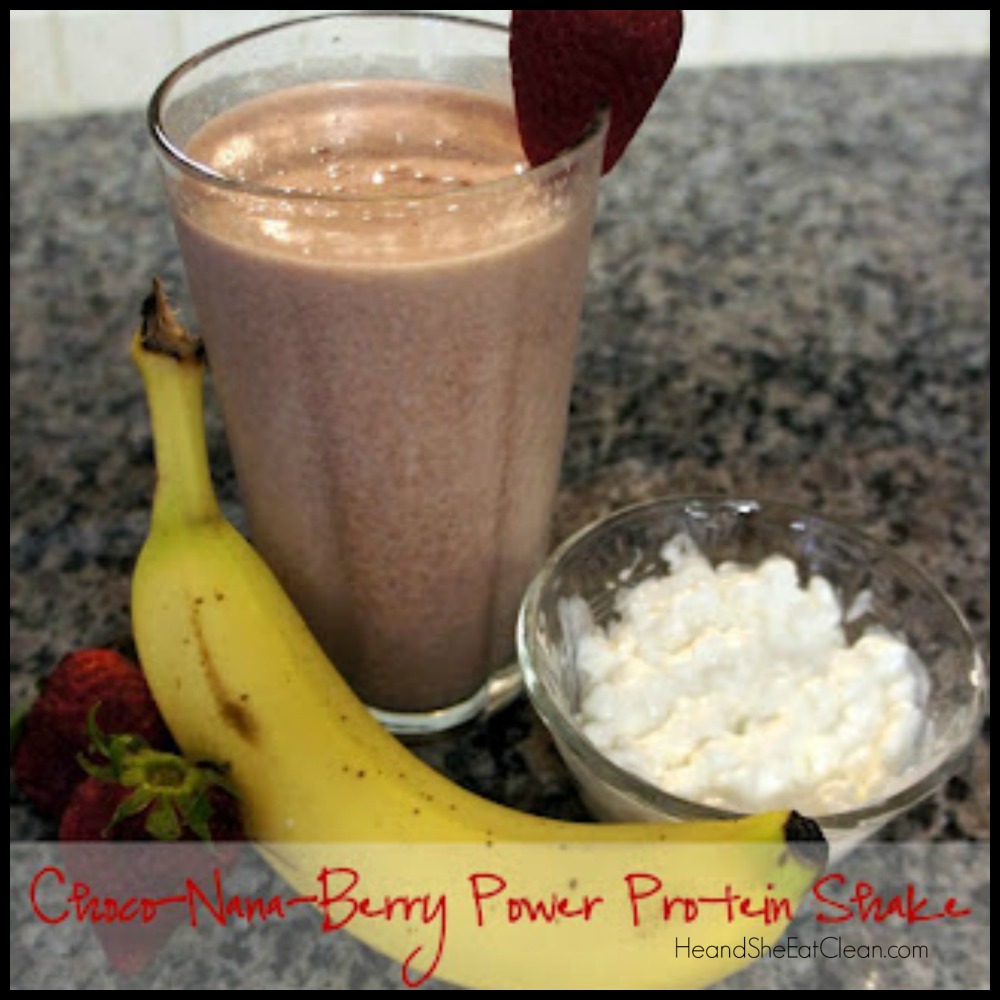 chocolate protein shake in a glass cup with a strawberry on top and banana and cottage cheese in front