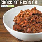 bison chili in a white bowl on a wooden table