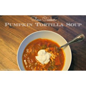 Pumpkin Tortilla Soup in a white bowl on a wooden table