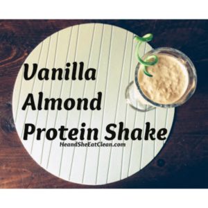 vanilla almond protein shake in a clear glass on a blue placemat