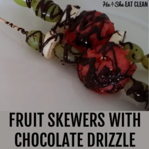 2 fruit skewers with chocolate drizzle on a white plate