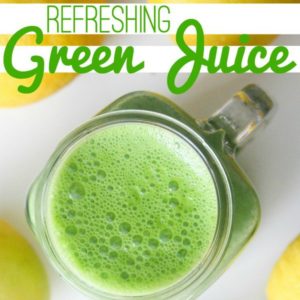 green juice in a clear glass with lemons on a white tabletop with text that reads refreshing green juice square image