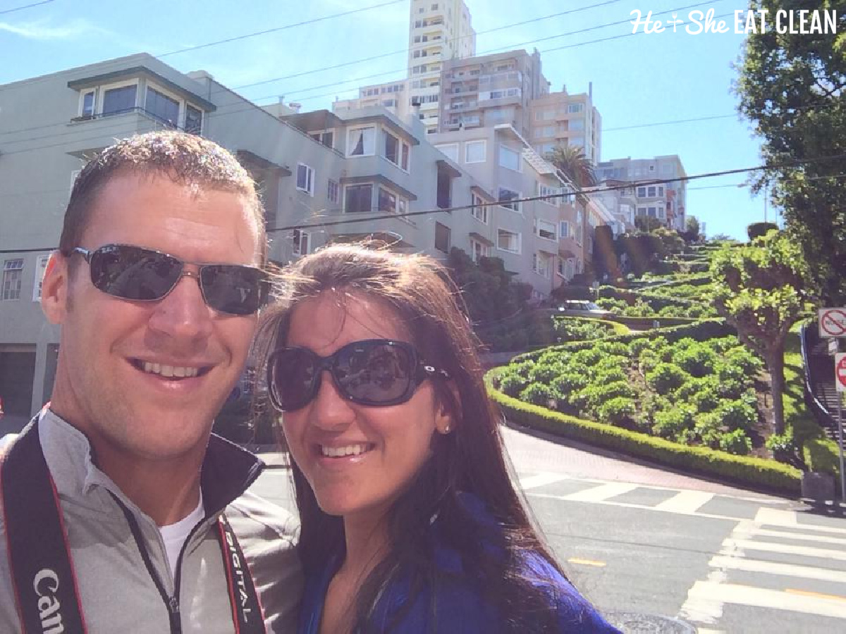 male and female couple standing below Lombard Street in California