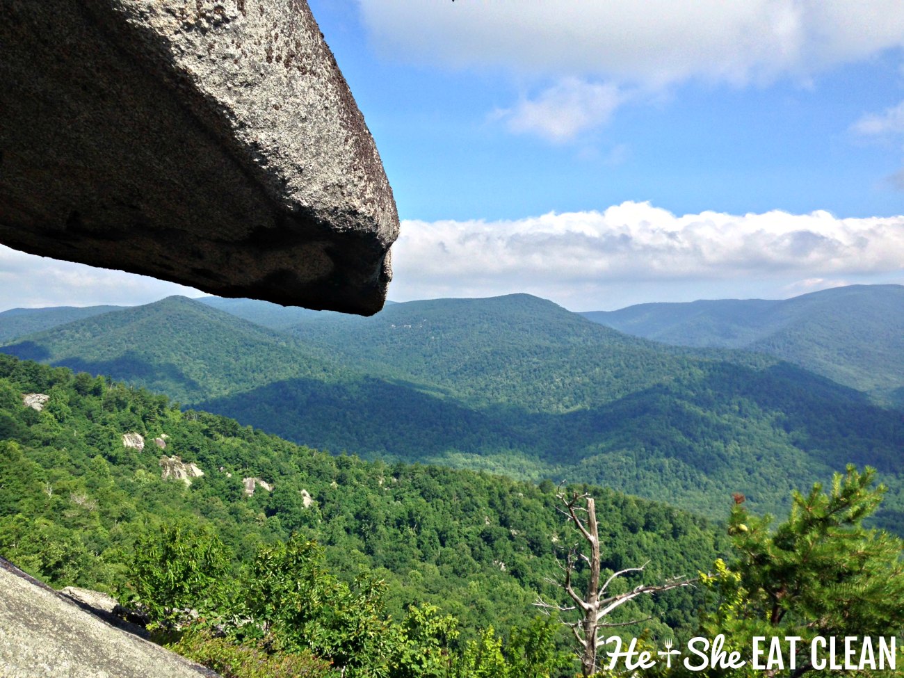 landscape photo of a rock ledge and green mountains in the background in Shenandoah National Park on Old Rag Mountain Trail