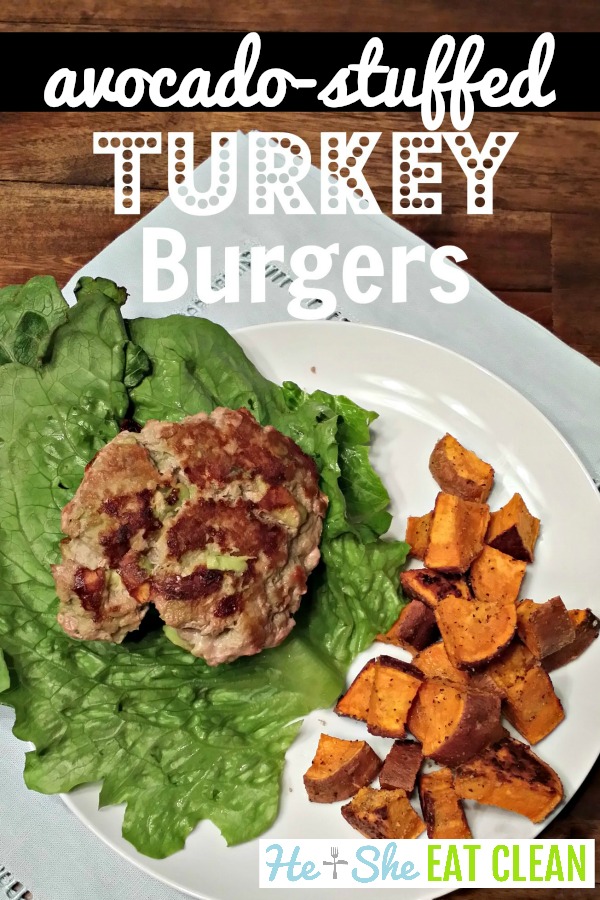 avocado-stuffed turkey burgers with lettuce and sweet potato cubes on a white plate