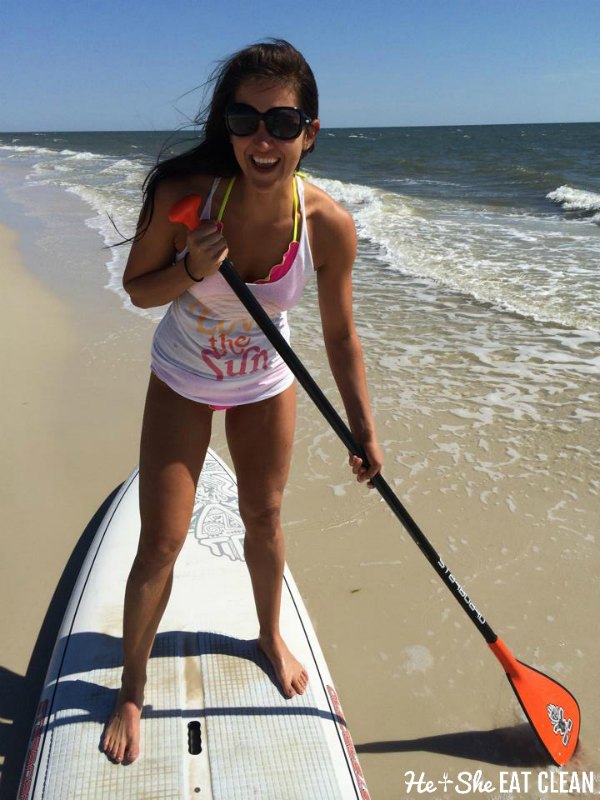 girl standing on paddle board at the beach
