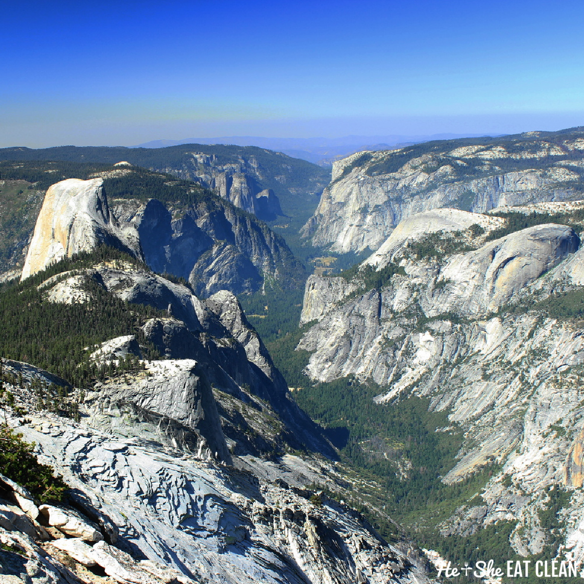 view of Half Dome in Yosemite National Park: granite mountains with blue sky 