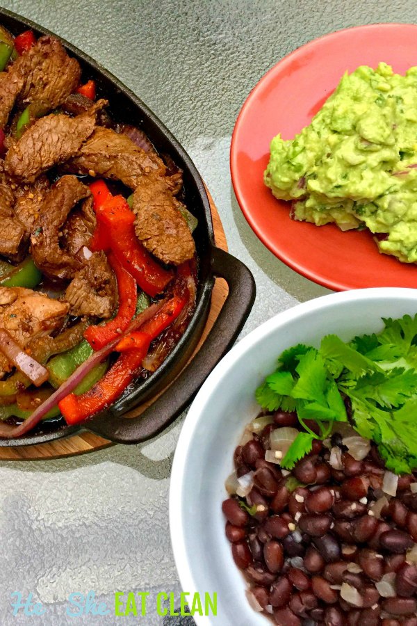 dish of fajitas, bowl of black beans, and plate of guacamole