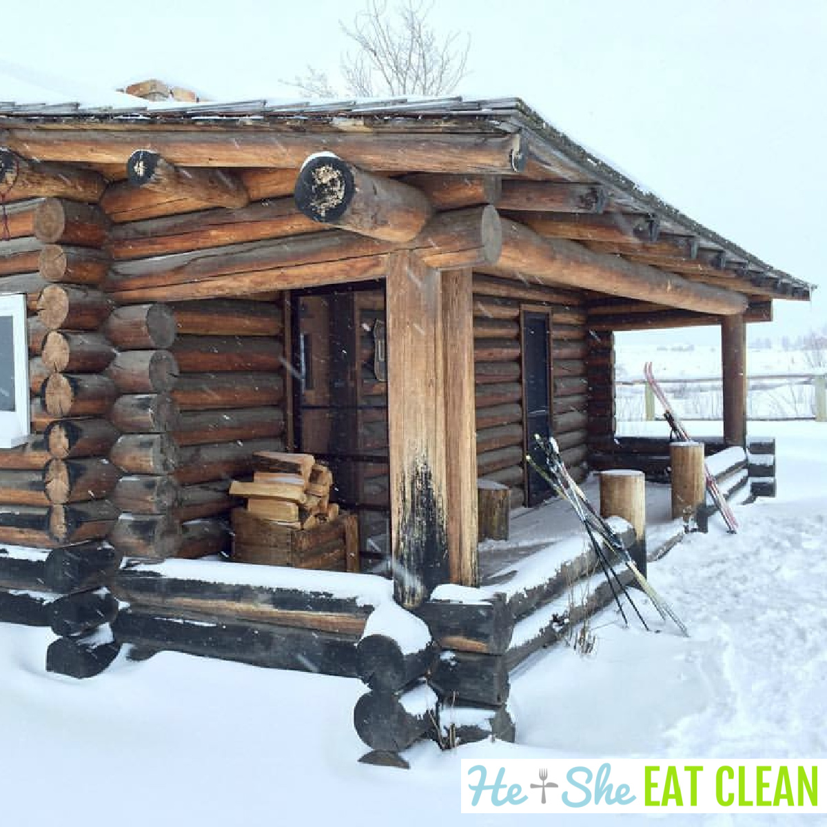 log wood cabin with snow and skis leaning on the front porch