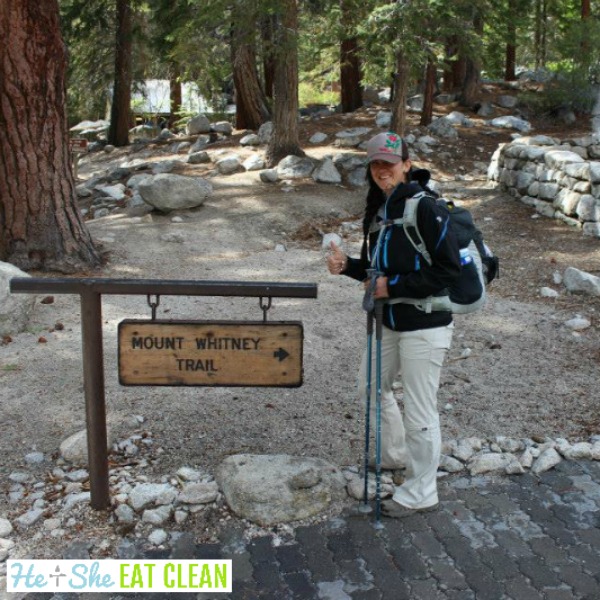 female standing next to the sign at the start of the Mount Whitney Trail in California