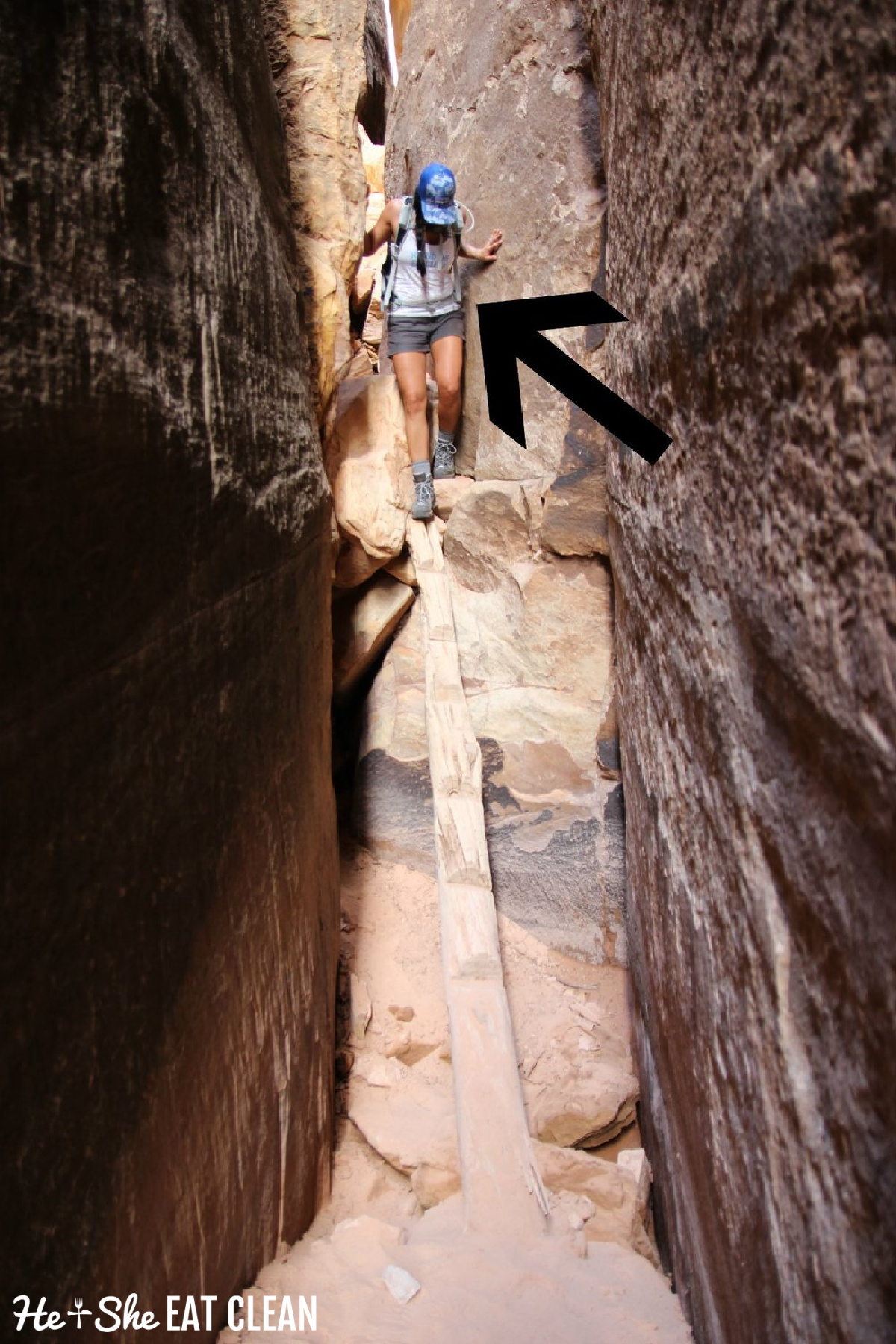 female hiker going down a wooden ladder into a slot in Canyonlands National Park