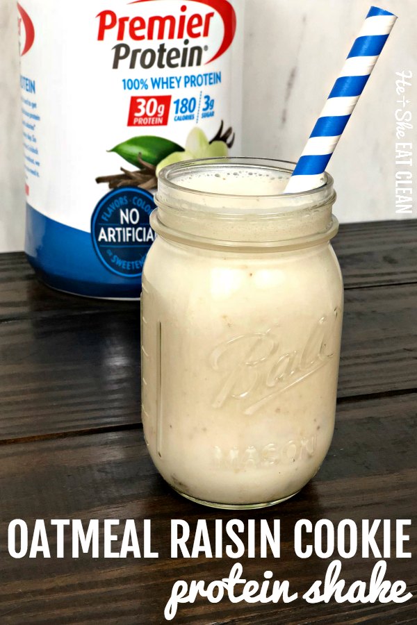vanilla protein shake in a glass Mason jar with a blue and white straw, protein powder canister in the back on a wooden table