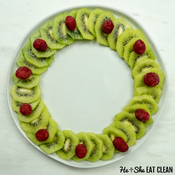 kiwi and raspberries arranges in a wreath on a white plate