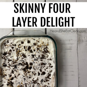 white Pyrex dish of four layer dessert with cookie crumbs & chocolate chips on top placed on a white tabletop