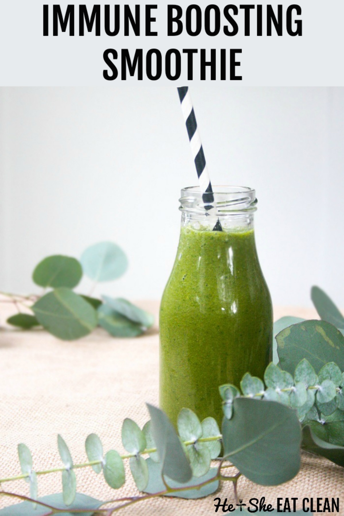 green juice in a glass bottle with a black and white straw