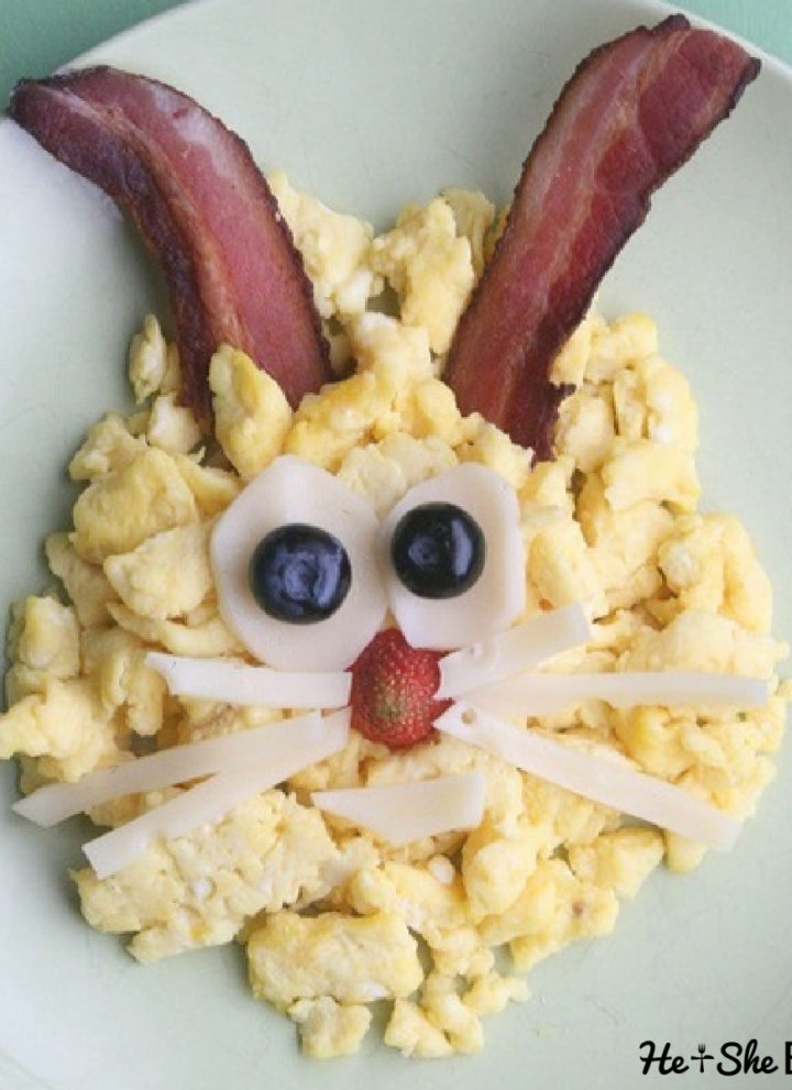 scrambled eggs made to look like a bunny with bacon ears and cheese eyes and whiskers