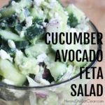side view of a glass bowl Cucumber, Avocado, & Feta Salad with onions