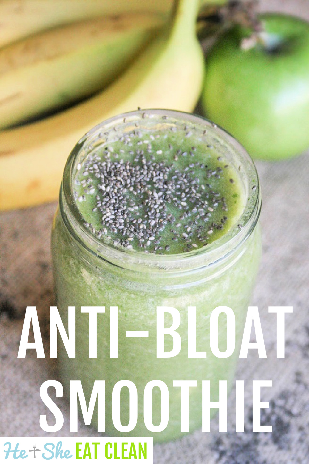 green smoothie topped with black chia seeds in a clear glass jar with a banana and apple in the background